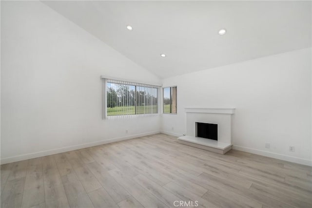 3180 Little Mountain Dr Unit D, San Bernardino, CA 92405 - unfurnished living room with high vaulted ceiling, a fireplace with raised hearth, recessed lighting, light wood-style flooring, and baseboards