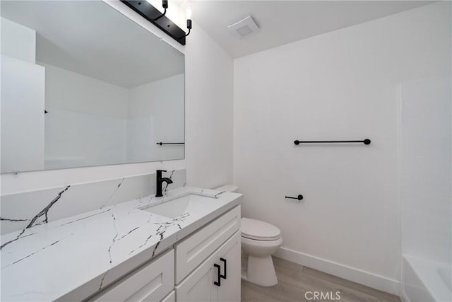 3180 Little Mountain Dr Unit D, San Bernardino, CA 92405 - bathroom featuring vanity, toilet, wood finished floors, baseboards, and tub / shower combination