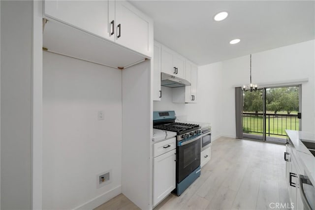 3180 Little Mountain Dr Unit D, San Bernardino, CA 92405 - kitchen with stainless steel appliances, under cabinet range hood, white cabinetry, light countertops, and a chandelier