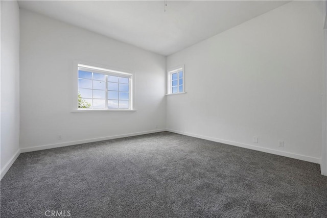 spare room featuring carpet and baseboards