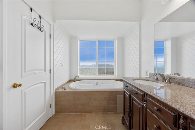 full bathroom with plenty of natural light, a bath, and vanity