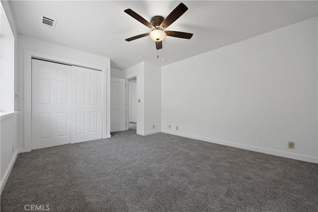unfurnished bedroom with carpet flooring, a closet, baseboards, and ceiling fan