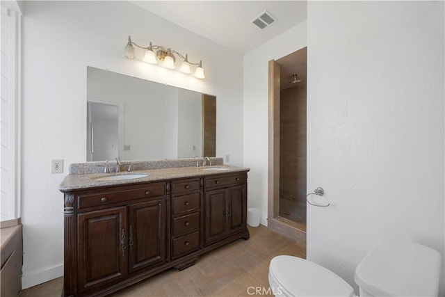 bathroom featuring toilet, a stall shower, and double vanity