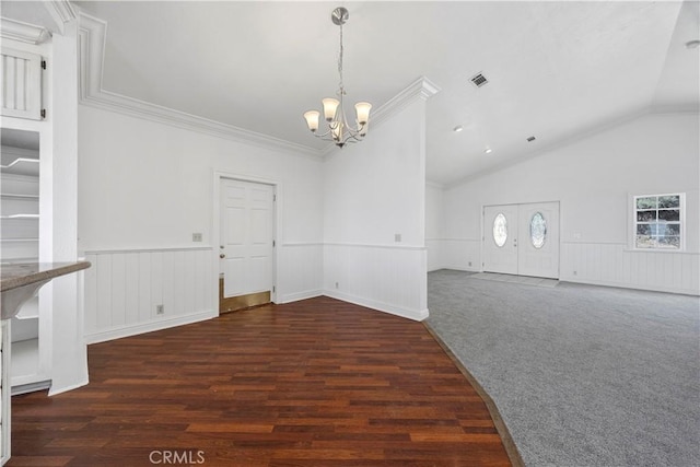spare room featuring a chandelier, a wainscoted wall, ornamental molding, lofted ceiling, and wood finished floors