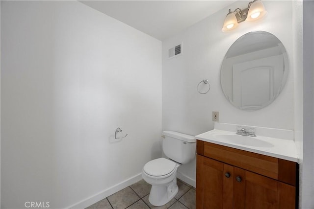 half bathroom featuring tile patterned floors, toilet, vanity, and baseboards
