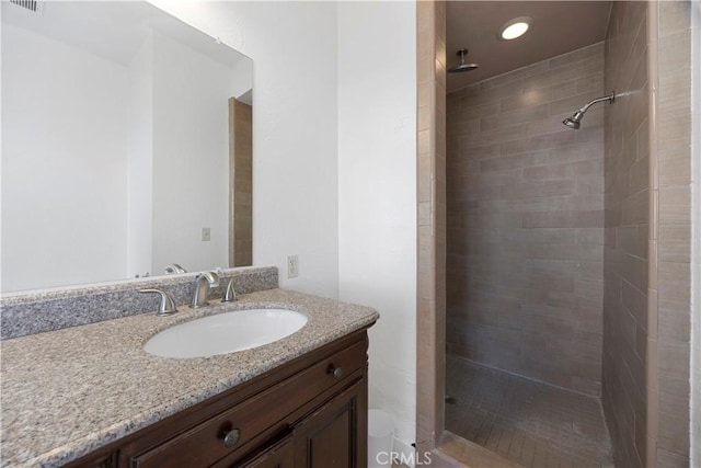 bathroom featuring tiled shower, vanity, toilet, and recessed lighting