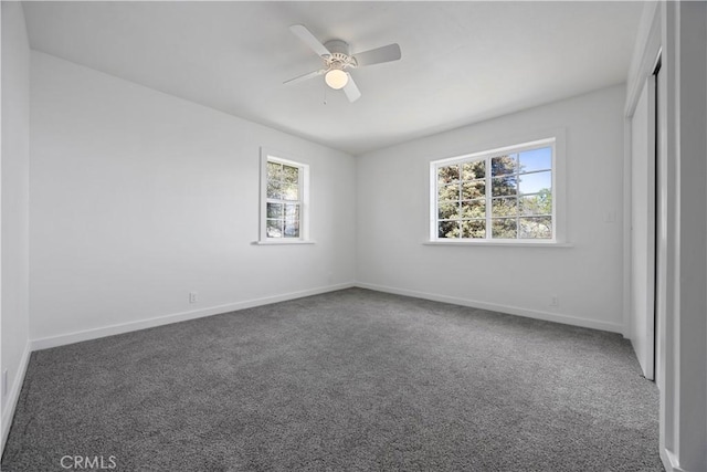 spare room featuring plenty of natural light, carpet flooring, and baseboards