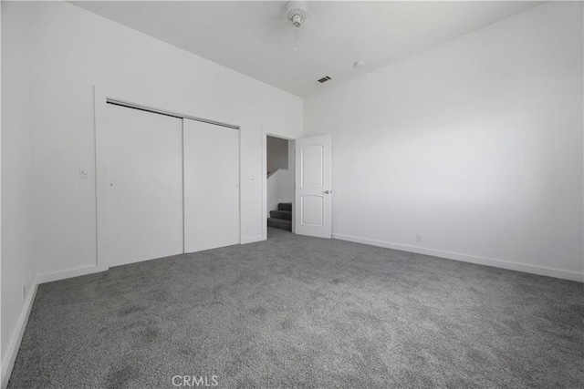 unfurnished bedroom featuring carpet floors, a closet, and baseboards