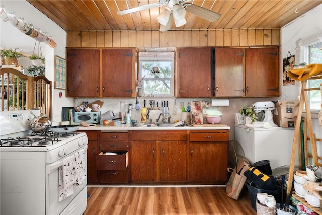 1825 Magnolia Ave, Chico, CA 95926 - kitchen featuring white range with gas stovetop, wooden ceiling, light wood-style flooring, light countertops, and washer and dryer