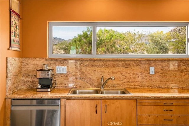 kitchen featuring stainless steel dishwasher, a sink, light countertops, and decorative backsplash