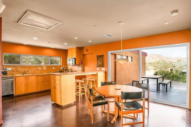 dining space with recessed lighting, attic access, and concrete floors