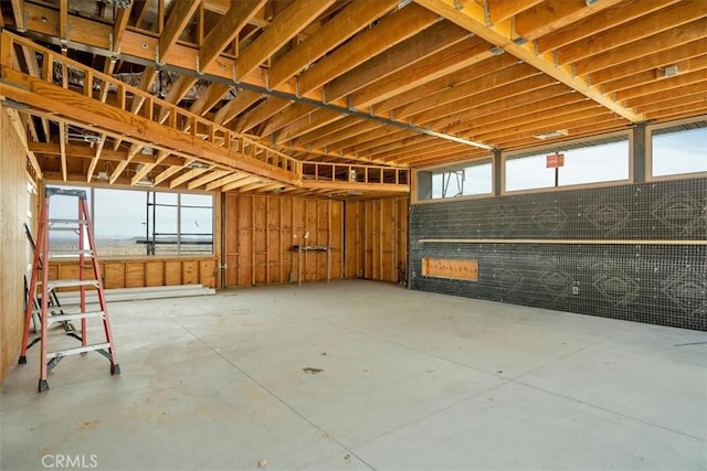 misc room featuring unfinished concrete floors and a garage