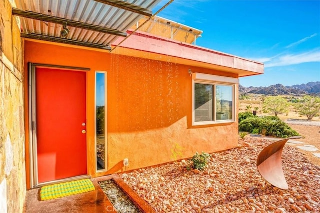 doorway to property featuring a mountain view and stucco siding