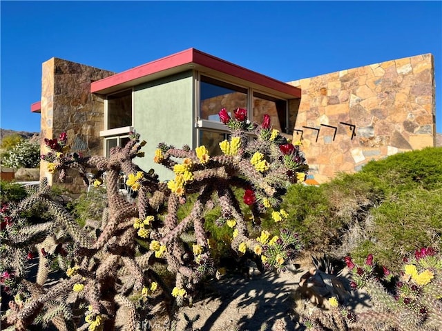 view of home's exterior featuring stone siding and stucco siding