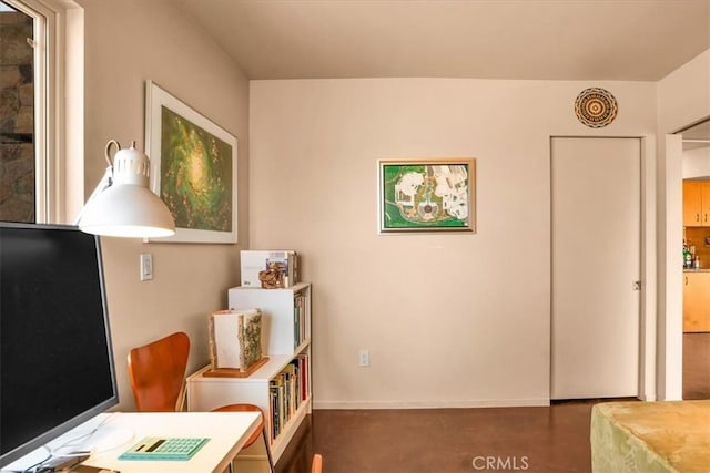sitting room with baseboards and an office area