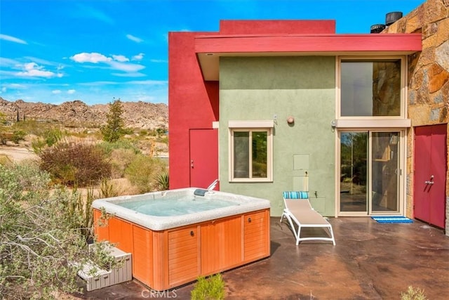 7078 Sunkist Rd, Joshua Tree, CA 92252 - back of house featuring a hot tub, a patio, and stucco siding