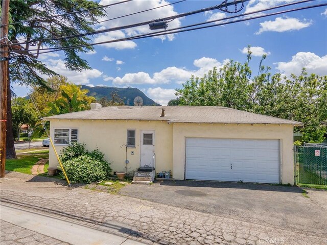 137 N Rose St, Burbank, CA 91505 - view of front of house featuring stucco siding, fence, a mountain view, and an attached garage