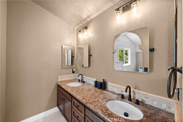 15 Vittoria St, Laguna Niguel, CA 92677 - bathroom featuring a textured wall, double vanity, and lofted ceiling