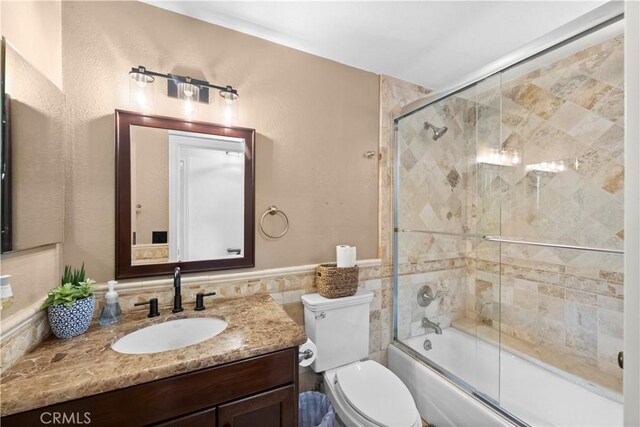 15 Vittoria St, Laguna Niguel, CA 92677 - full bathroom with vanity, toilet, bath / shower combo with glass door, wainscoting, and tile walls