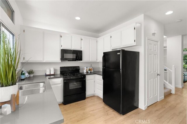 23622 Wakefield Ct Unit 69, Laguna Niguel, CA 92677 - kitchen with black appliances, a sink, light wood-style flooring, white cabinetry, and recessed lighting