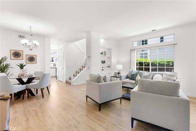 23622 Wakefield Ct Unit 69, Laguna Niguel, CA 92677 - living area with stairs, a chandelier, light wood-style floors, and baseboards
