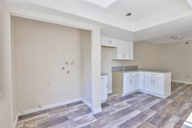 845 Daffodil Dr, Riverside, CA 92507 - kitchen with light wood-style floors, white cabinetry, baseboards, a peninsula, and a raised ceiling