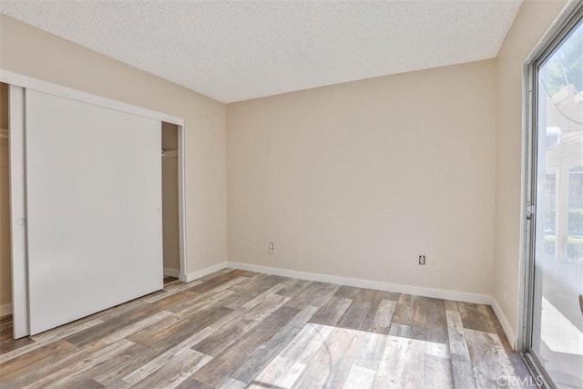 845 Daffodil Dr, Riverside, CA 92507 - unfurnished bedroom featuring a textured ceiling, wood finished floors, a closet, and baseboards
