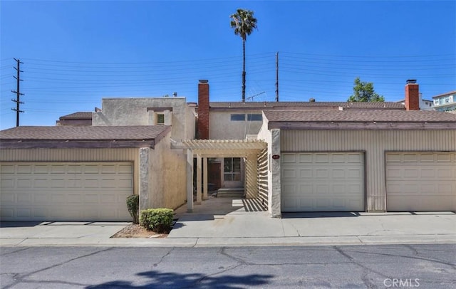 845 Daffodil Dr, Riverside, CA 92507 - view of property featuring a pergola, a shingled roof, a chimney, and community garages