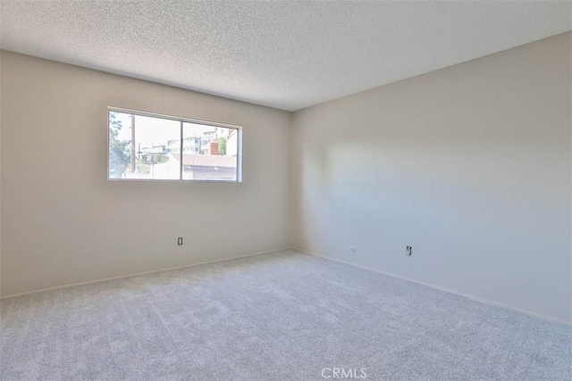 unfurnished room with carpet, a textured ceiling, and baseboards