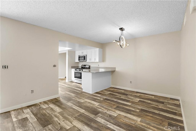 845 Daffodil Dr, Riverside, CA 92507 - kitchen with appliances with stainless steel finishes, a chandelier, wood finished floors, a textured ceiling, and white cabinets