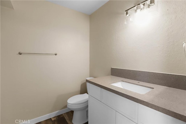 845 Daffodil Dr, Riverside, CA 92507 - bathroom featuring wood finished floors, toilet, vanity, and baseboards