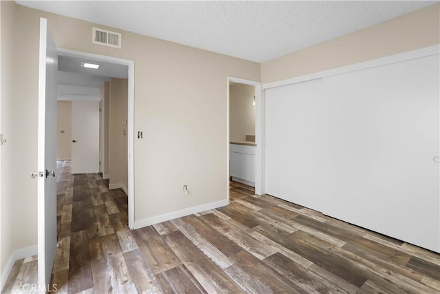 845 Daffodil Dr, Riverside, CA 92507 - unfurnished bedroom featuring a closet, wood finished floors, a textured ceiling, and baseboards