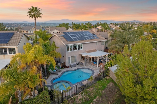 32871 Levi Ct, Temecula, CA 92592 - rear view of property with a fenced backyard, solar panels, stucco siding, a pergola, and a pool with connected hot tub