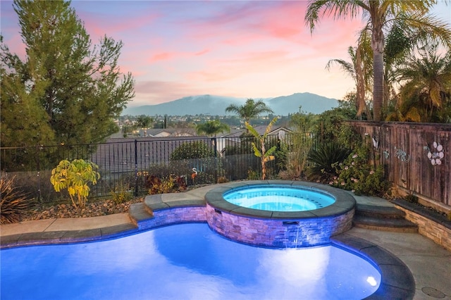 32871 Levi Ct, Temecula, CA 92592 - pool at dusk featuring a mountain view and a pool with connected hot tub