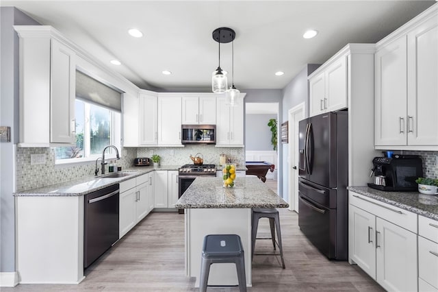 32871 Levi Ct, Temecula, CA 92592 - kitchen with appliances with stainless steel finishes, white cabinets, light stone counters, a breakfast bar, and backsplash