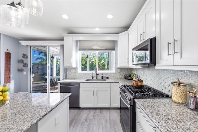 32871 Levi Ct, Temecula, CA 92592 - kitchen with stainless steel appliances, light wood-style floors, white cabinets, decorative backsplash, and recessed lighting