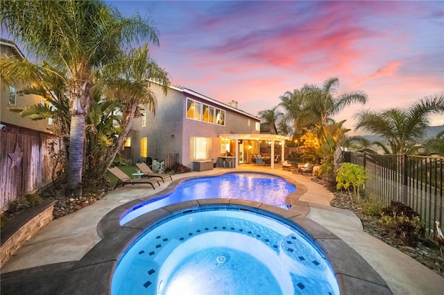 32871 Levi Ct, Temecula, CA 92592 - pool at dusk featuring an in-ground hot tub, a fenced backyard, a patio, and a pergola