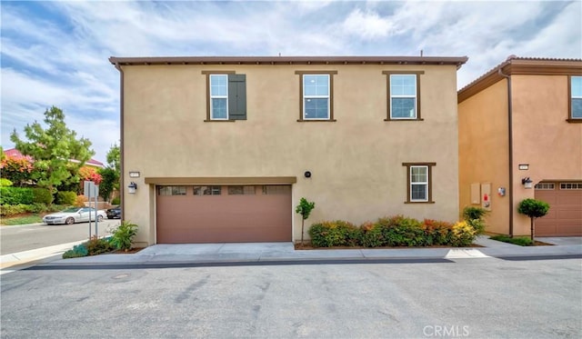 14533 Verona Pl, Eastvale, CA 92880 - view of front of home featuring an attached garage, stucco siding, and driveway