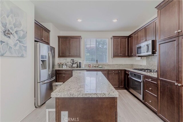 14533 Verona Pl, Eastvale, CA 92880 - kitchen with stainless steel appliances, a kitchen island, a sink, dark brown cabinetry, and recessed lighting