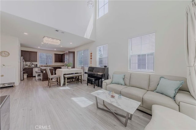 14533 Verona Pl, Eastvale, CA 92880 - living area featuring healthy amount of natural light, light wood-style flooring, and a high ceiling