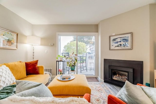 150 Cypress Ave Unit 28, Cayucos, CA 93430 - living room with a glass covered fireplace, baseboards, and wood finished floors