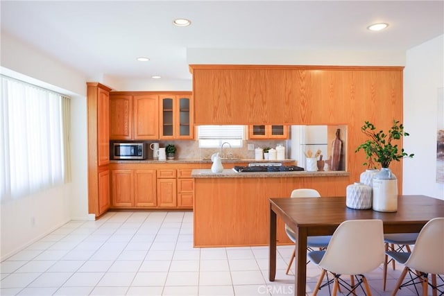 3844 W 181st St, Torrance, CA 90504 - kitchen featuring freestanding refrigerator, stainless steel microwave, a sink, glass insert cabinets, and tasteful backsplash