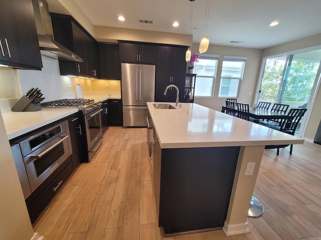 2072 Tango Loop Unit 2, Chula Vista, CA 91915 - kitchen with stainless steel appliances, wall chimney range hood, a sink, light wood-style floors, and recessed lighting