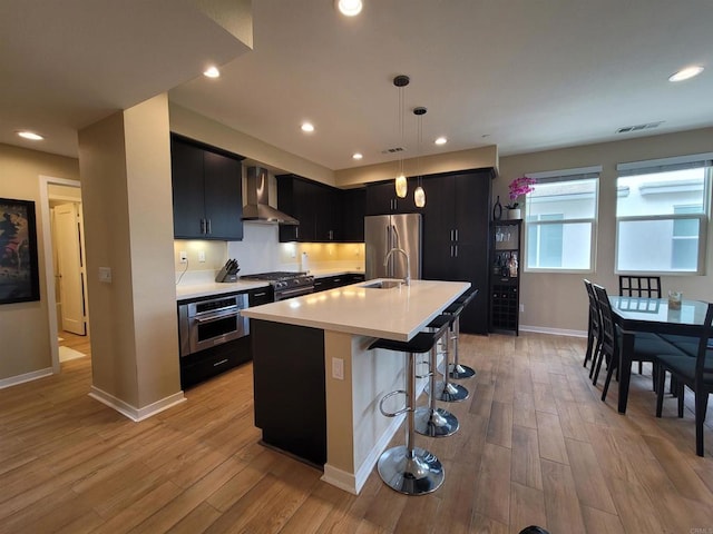 2072 Tango Loop Unit 2, Chula Vista, CA 91915 - kitchen with wall chimney exhaust hood, high quality appliances, dark cabinetry, light countertops, and a sink