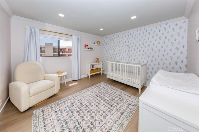 bedroom with crown molding, light wood-style flooring, wallpapered walls, baseboards, and recessed lighting