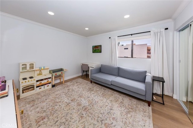 living area with crown molding, wood finished floors, recessed lighting, and baseboards