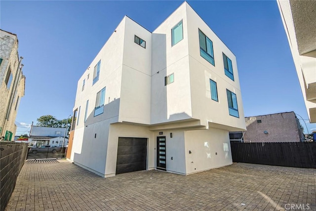 2202 Thurman Ave, Los Angeles, CA 90016 - view of front facade featuring stucco siding, a garage, fence, and decorative driveway