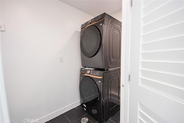 2202 Thurman Ave, Los Angeles, CA 90016 - clothes washing area featuring stacked washer / drying machine, dark tile patterned floors, and baseboards