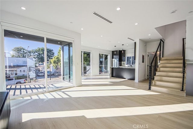 2202 Thurman Ave, Los Angeles, CA 90016 - unfurnished living room with light wood-type flooring, stairs, and recessed lighting