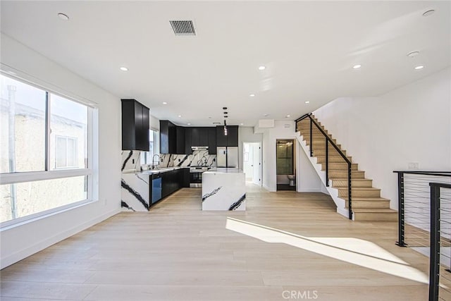 2202 Thurman Ave, Los Angeles, CA 90016 - unfurnished living room with a sink, light wood finished floors, stairs, recessed lighting, and baseboards